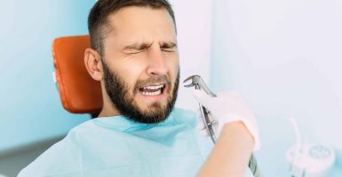A man treats his teeth at the dentist. Dental examination at the dentist. Dental care. A man is afraid to treat his teeth. Fear of treating teeth. Tooth extraction at the dentist's office. Copy space